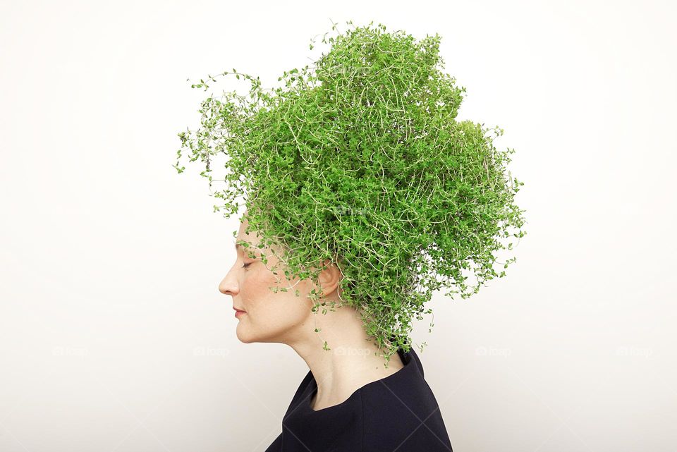 Woman with green thyme hair on white background