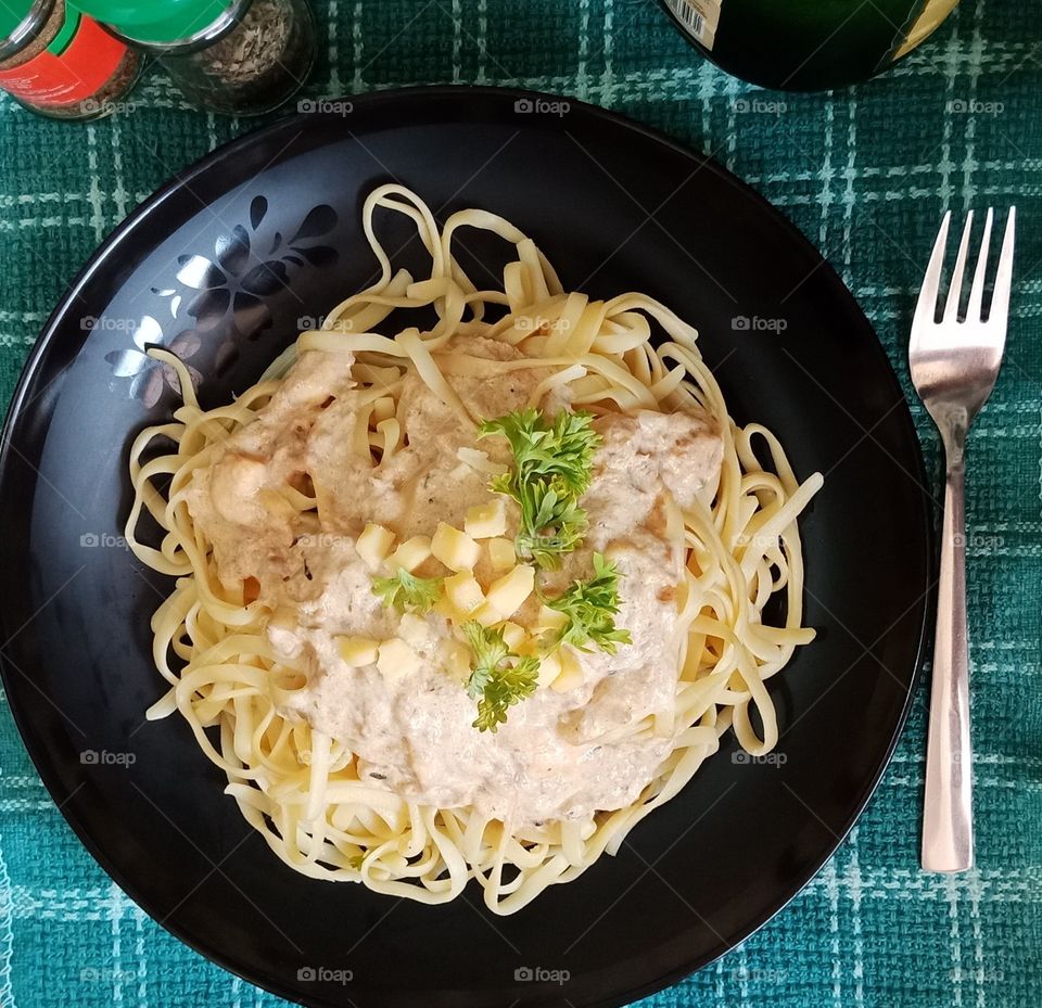 Spicy tuna carbonara fettuccine topped with cheese and parsley