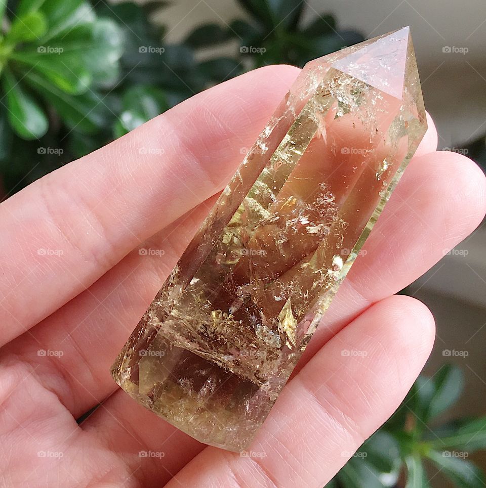 A polished yellow citrine quartz crystal tower point.