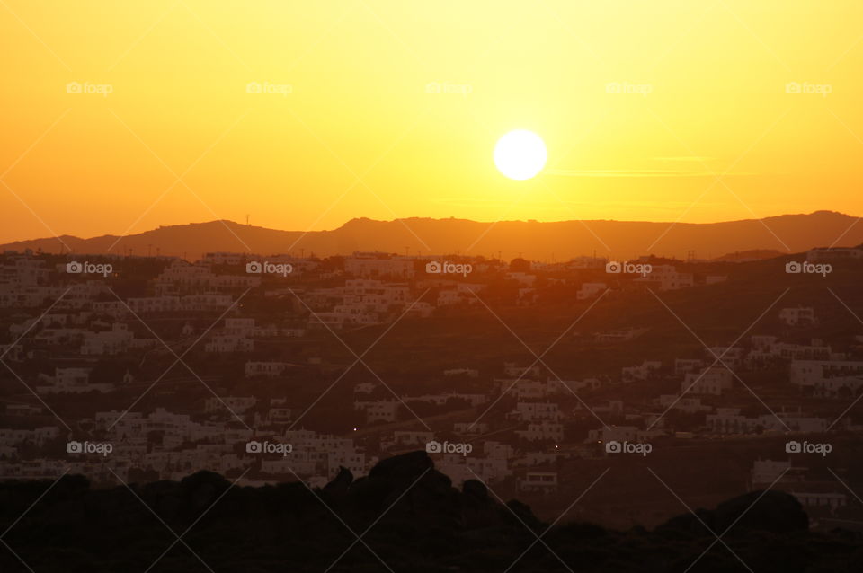 Mykonos Sunrise - Sun just peaking over the city of Mykonos, Greece.