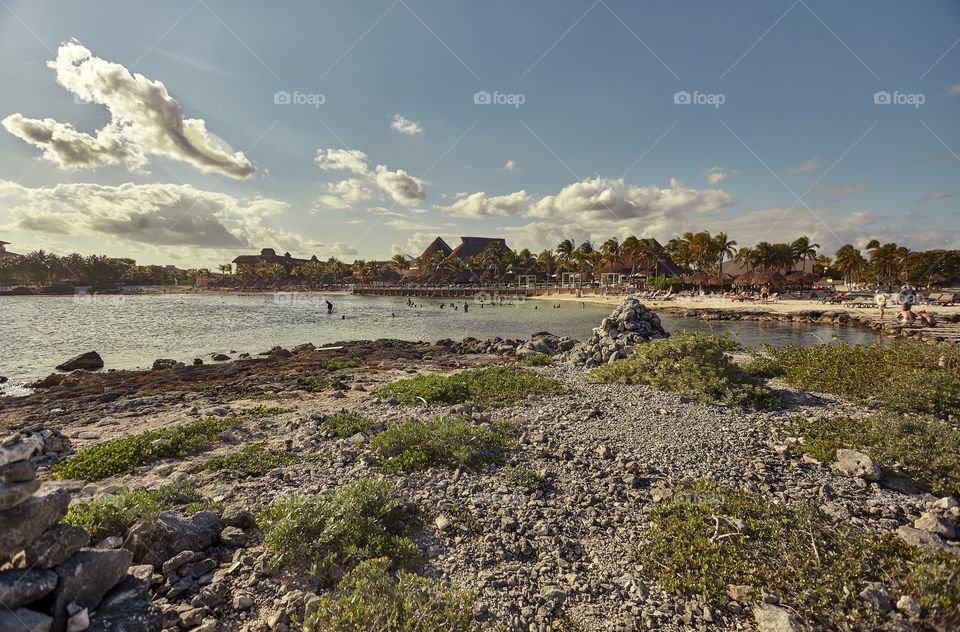Detail of the view of Puerto Aventuras beach in Mexico with some seagulls flying from the sea to the coast.