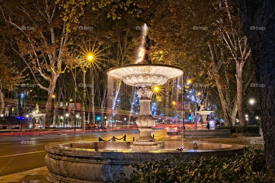 Fountains in a illuminated street of Madrid 