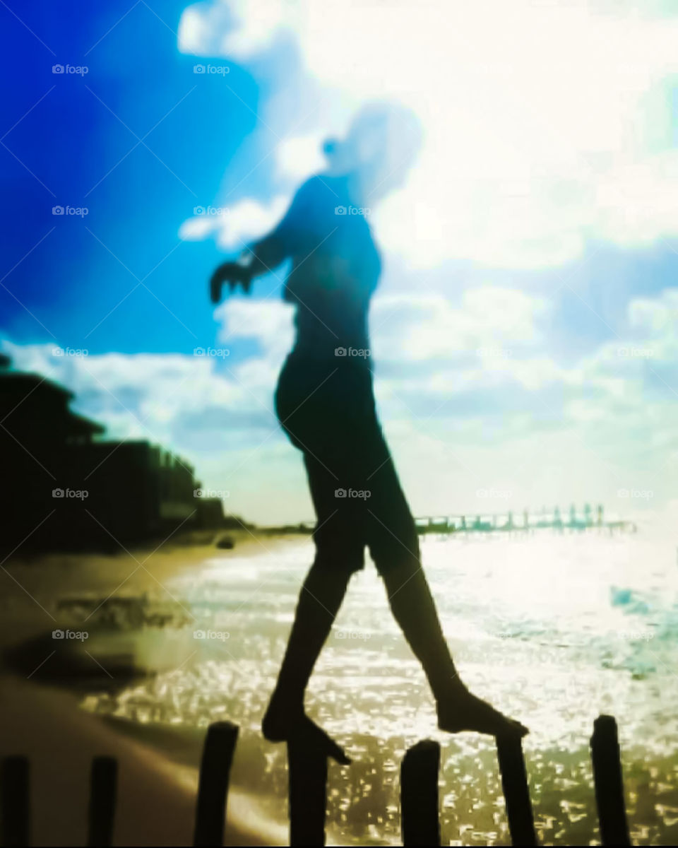 focusing girl walking on logs on the shore of the beach