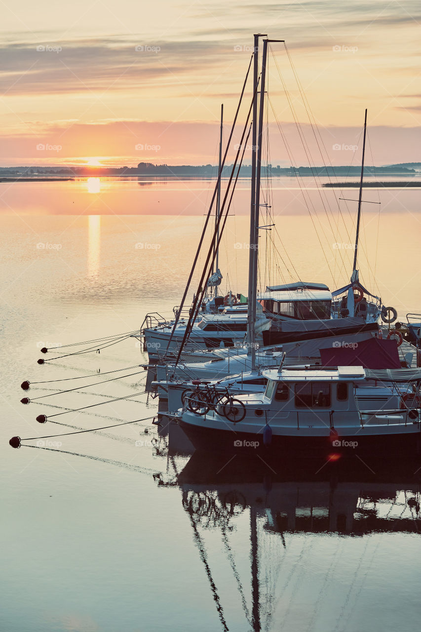 Yachts and boats moored in a harbour at sunrise. Candid people, real moments, authentic situations