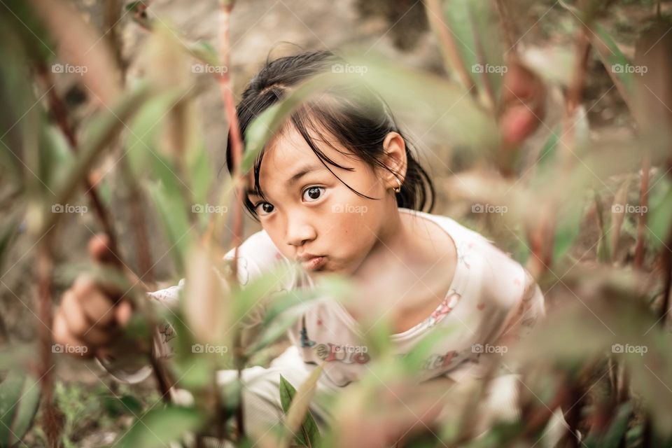 A candid shot of a young little girl examining plants like an expert botanist