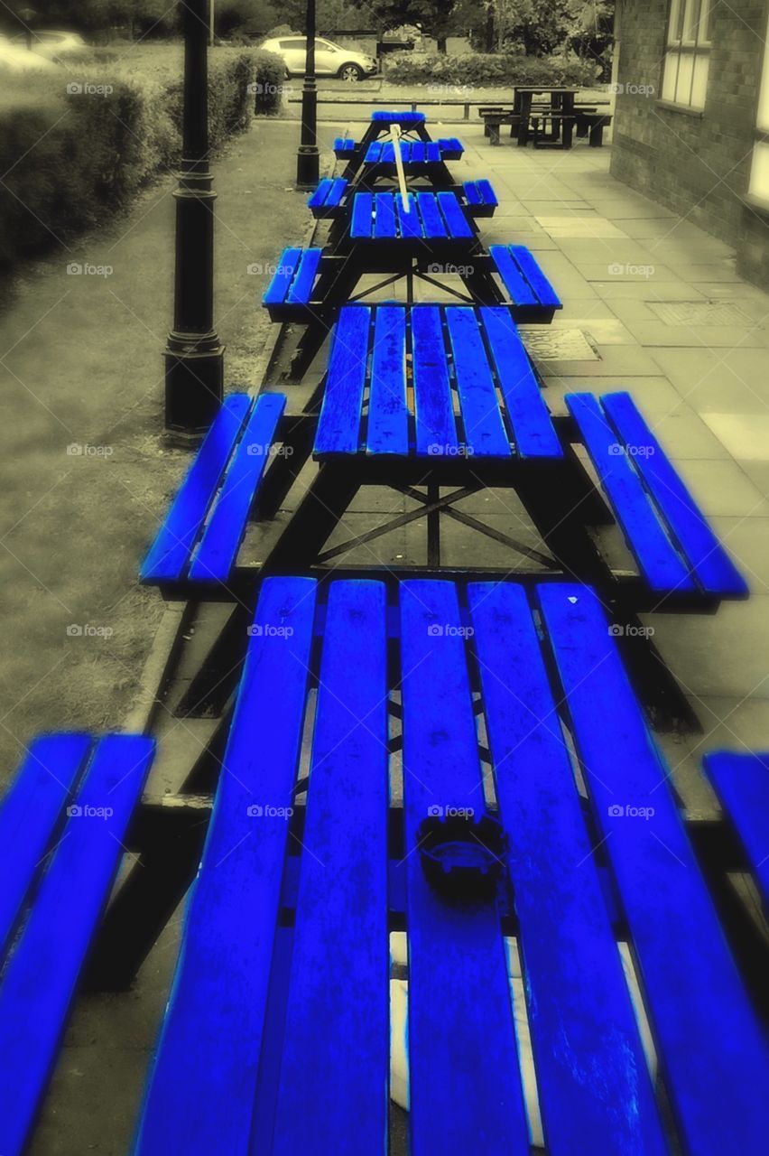 Pub benches . Straight line perspective view of pub benches splashed with electric blue.