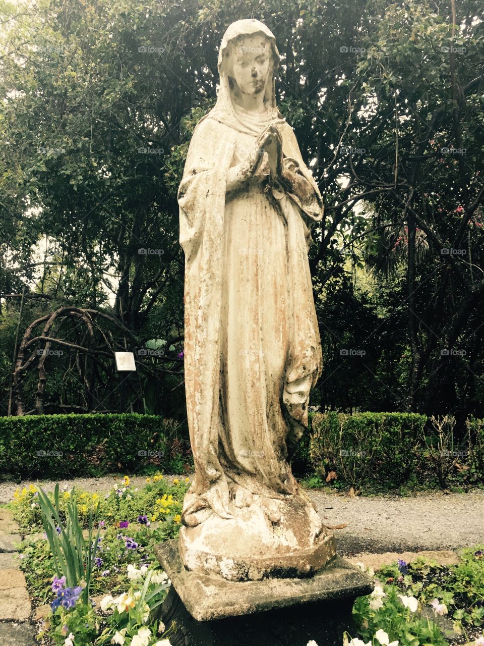 A statue of a woman watches over a garden
