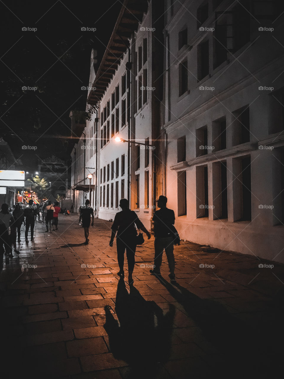 Silhouette and shadow of people walking in the town square of the city.