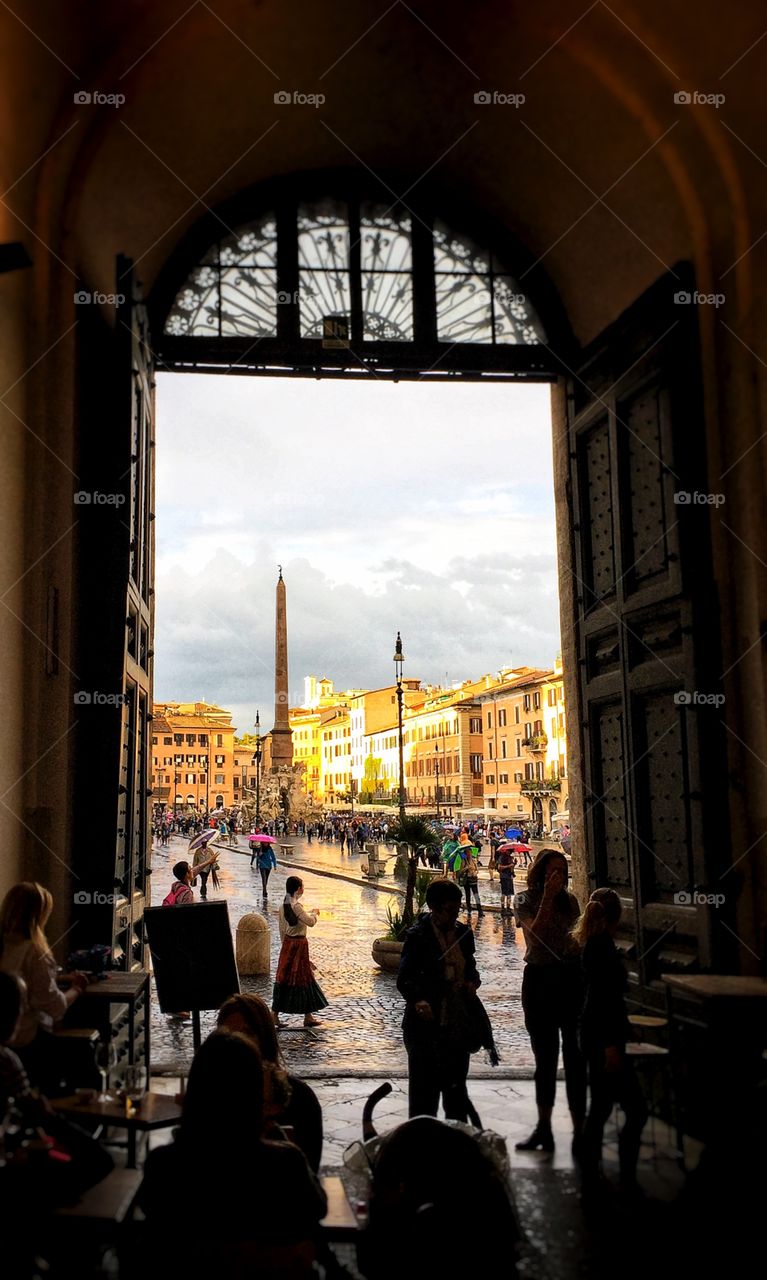 Piazza Navona in Rome Italy seen through an arched doorway on a rainy afternoon 