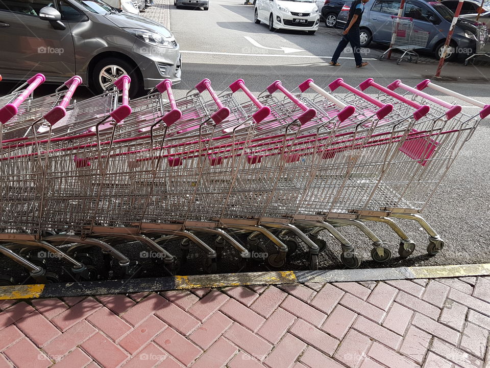 Empty line-up of shopping trolleys/ carts stacked in a row
