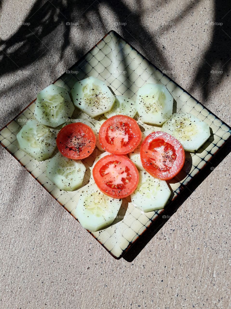 Sliced cucumber and tomato salad with fresh ground pepper