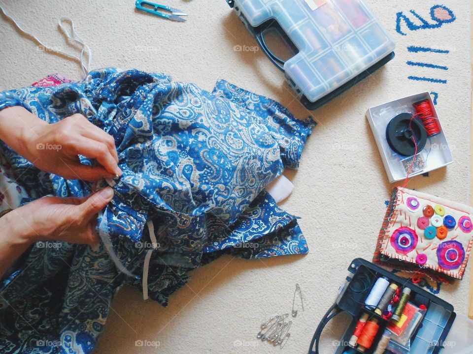 The girl is sewing a fashionable dress