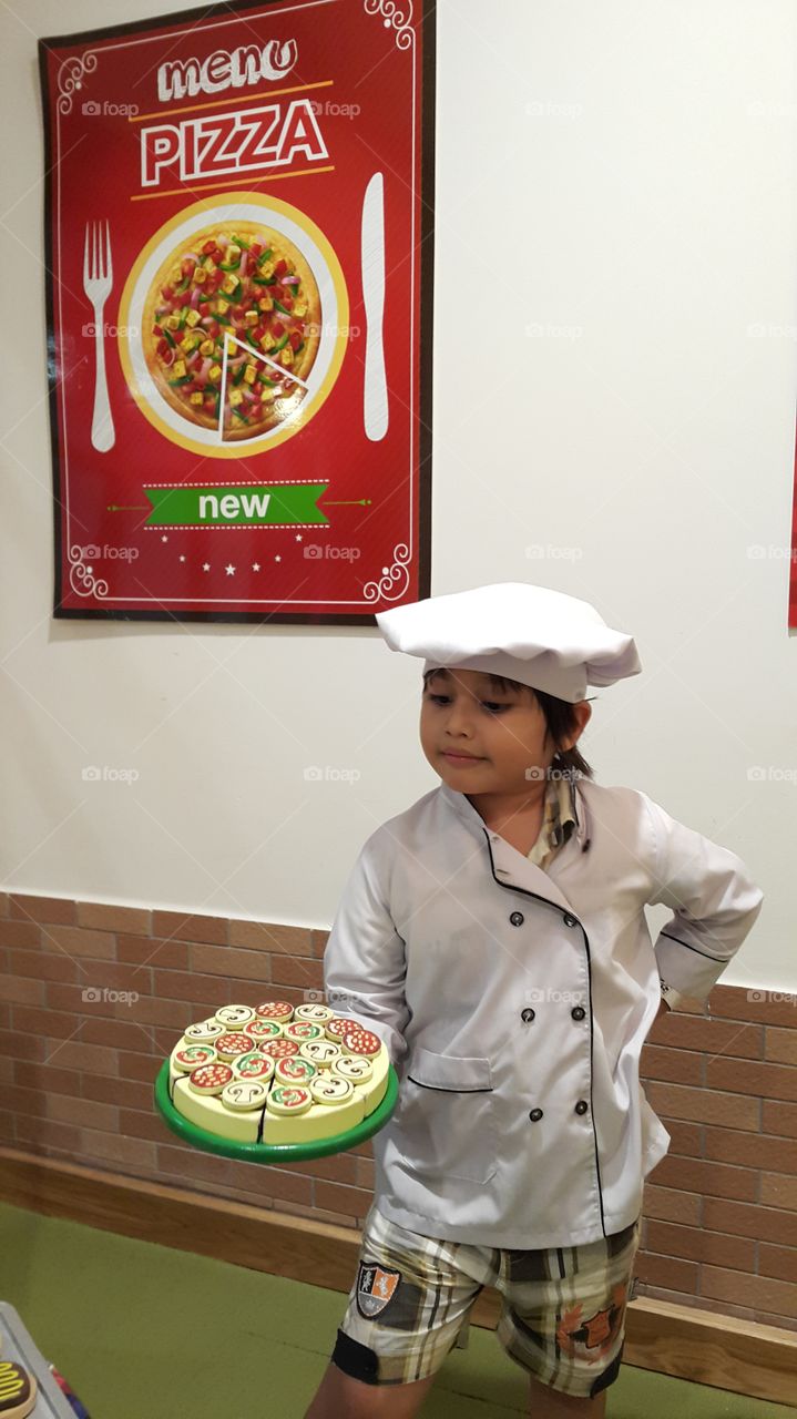 Young Italian chef. kid wearing chef uniform  playing