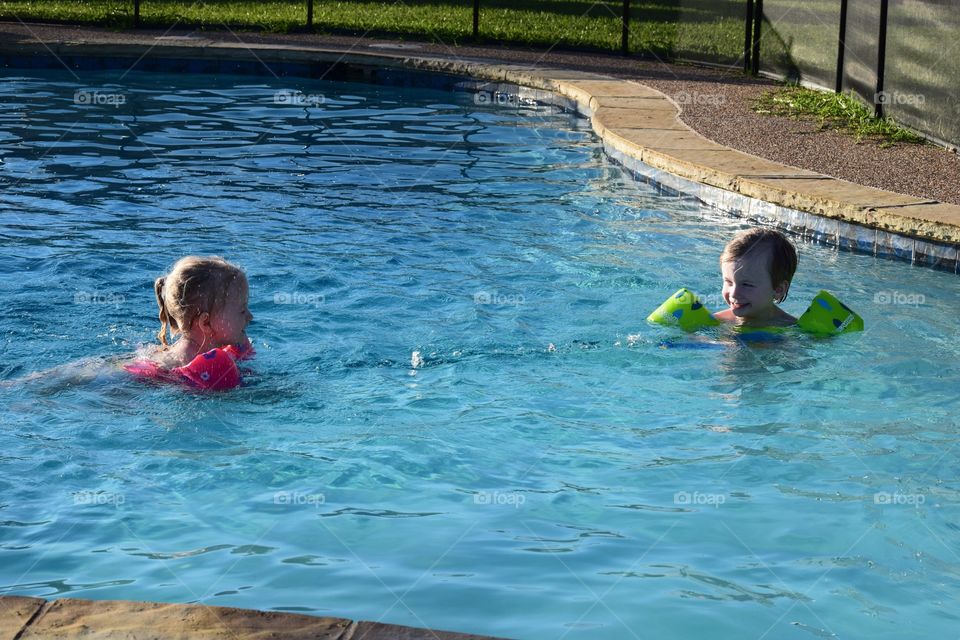 Siblings playing in the pool