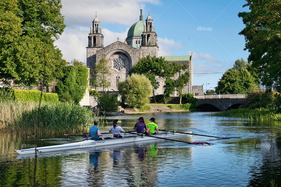 Group of people kayaking in Corrib river at Galway Cathedral, Ireland