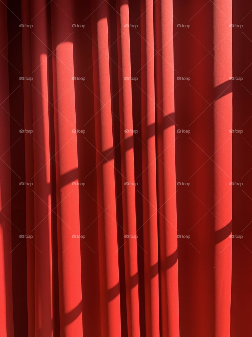 a red curtain draped with a diagonal light giving a dramatic effect