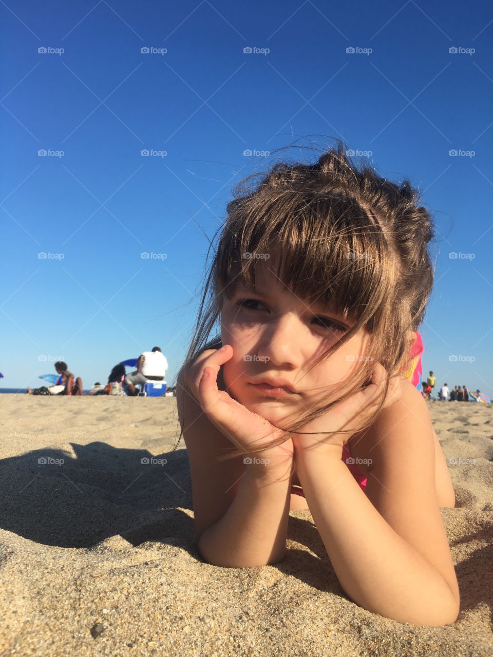 Sad girl lying on beach
