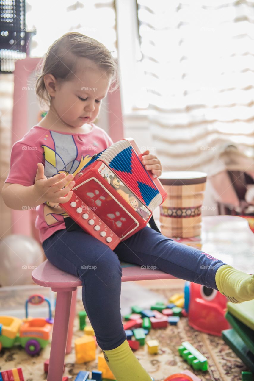 Cute baby playing with accordion