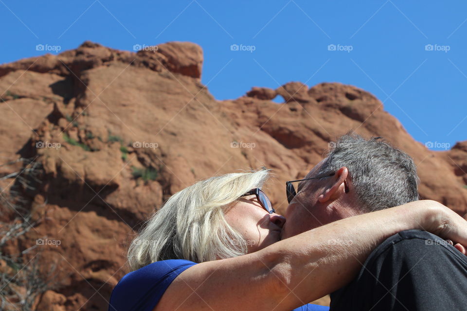 Kissing couple at the base of Kissing Camels in Garden of the Gods in Colorado Springs, Colorado. 