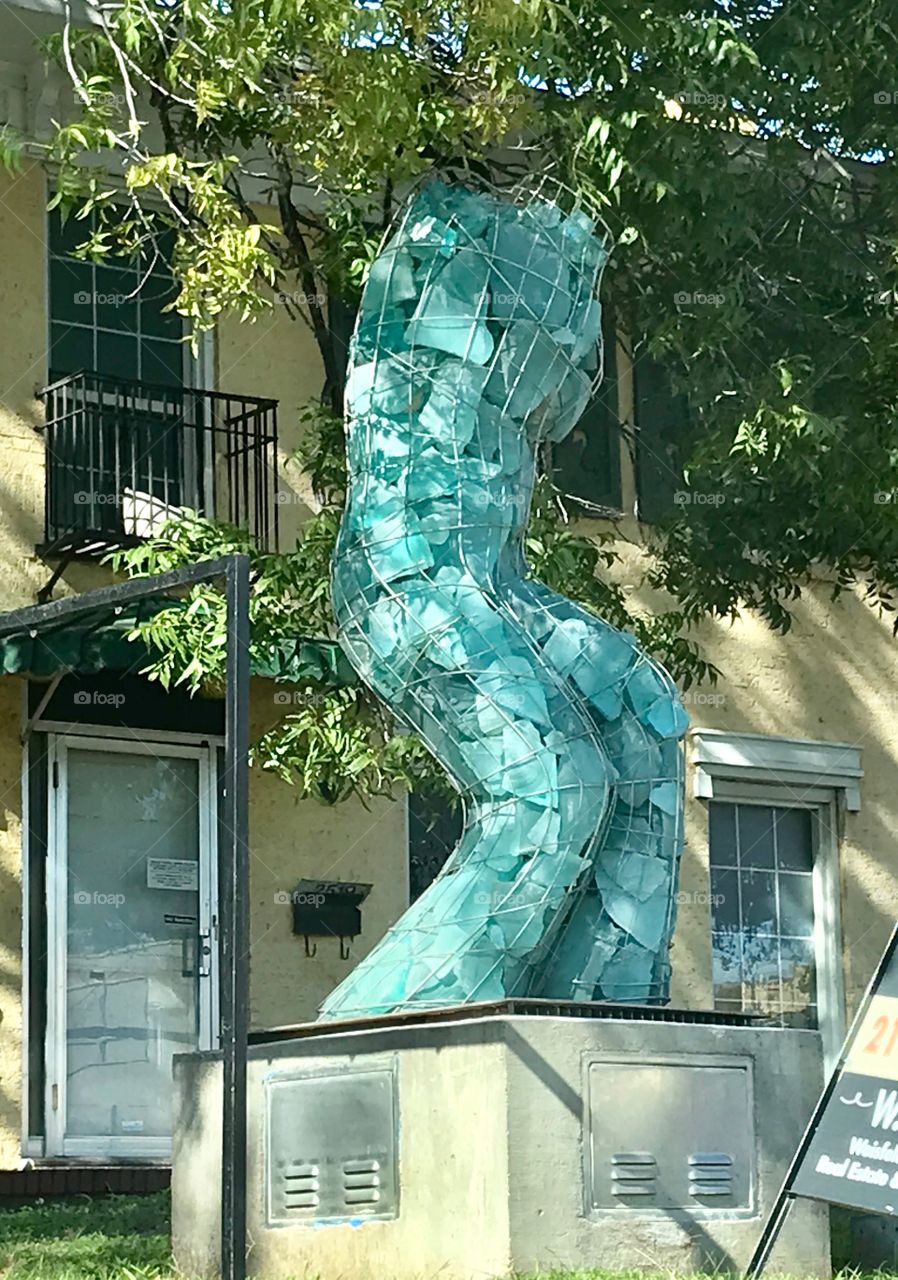 Headless wire sculpture of body with turquoise colored rocks inside in Dallas Texas TX