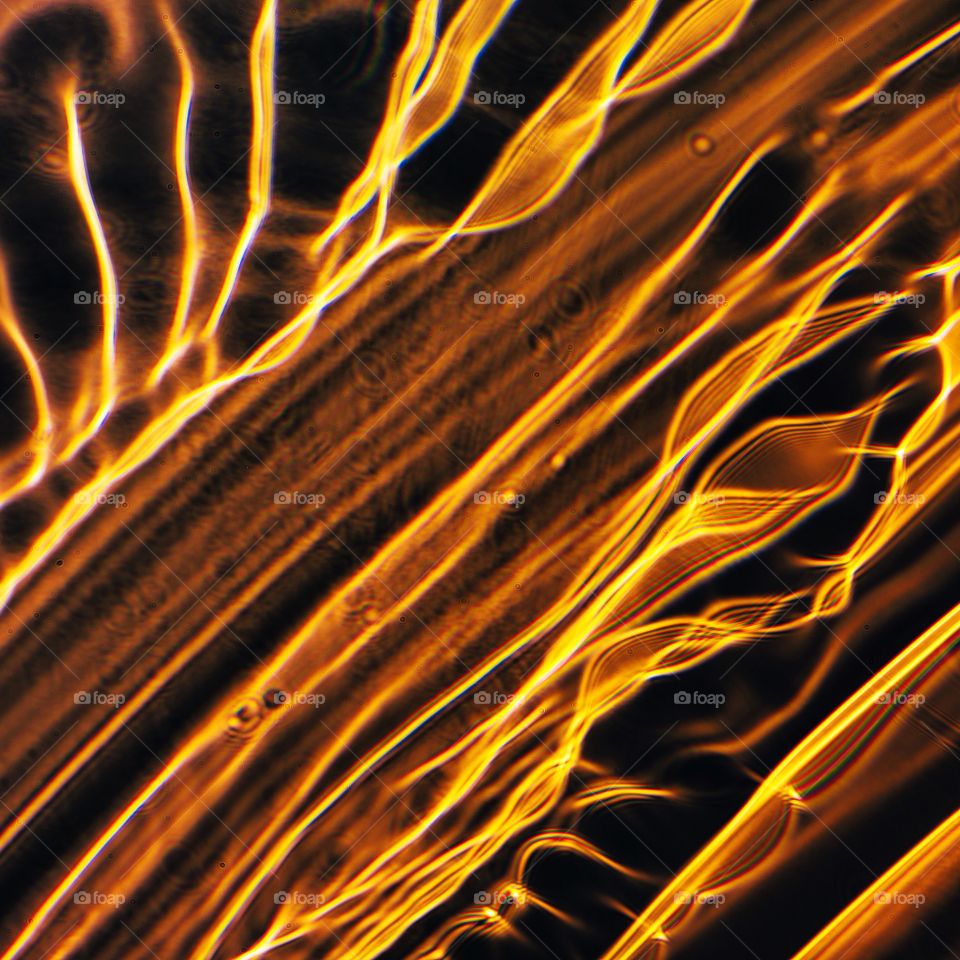 A Refraction in a hand blown glass yellow rondel like flames or waves of honey hitting the sun light