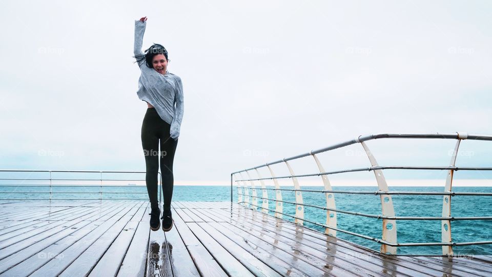 Woman jumping on pier