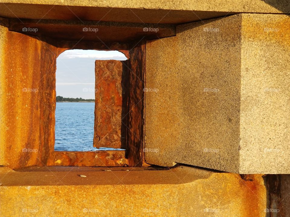 Another beautiful shot of the window of an old abandoned war fort and its ocean view at bug light park in south portland, maine