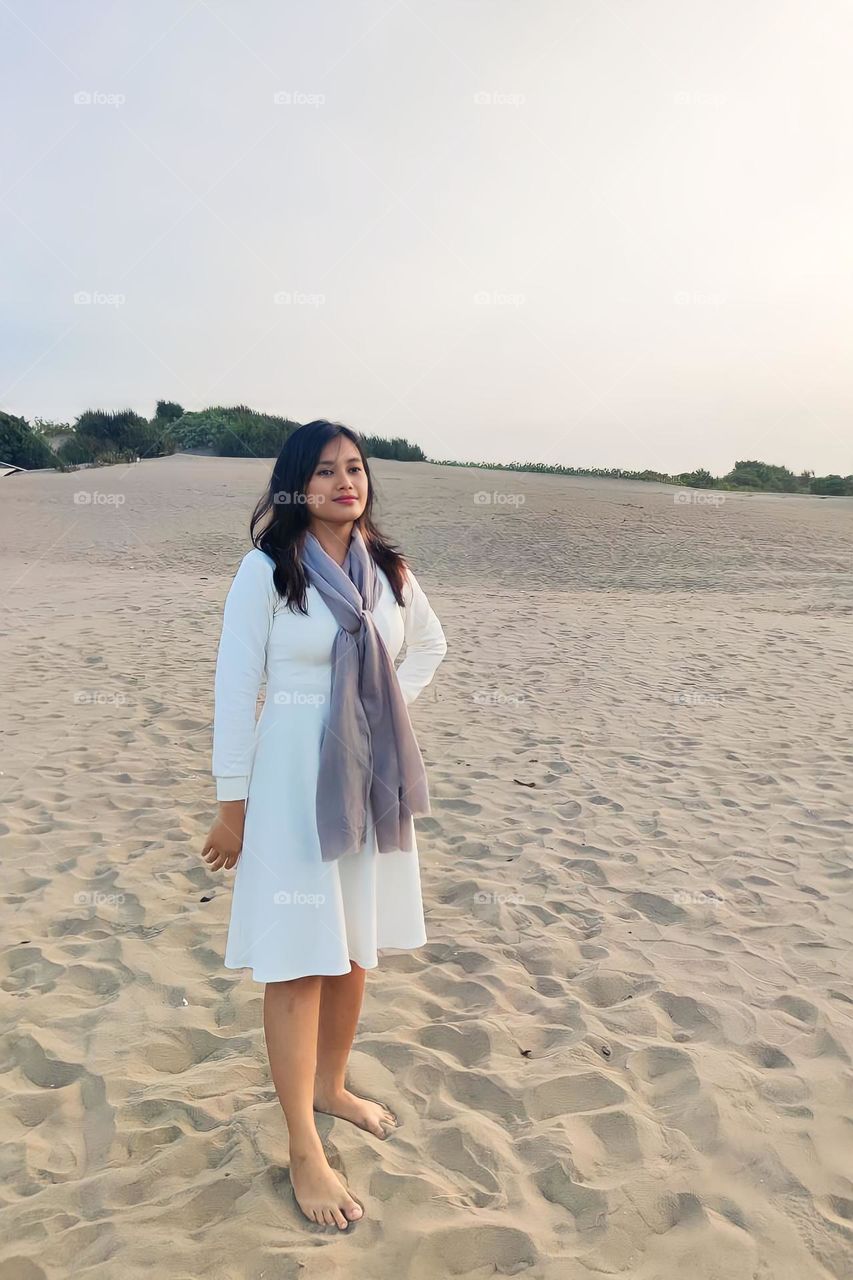 Portrait of a young woman on holiday on a white sand beach on a sunny afternoon