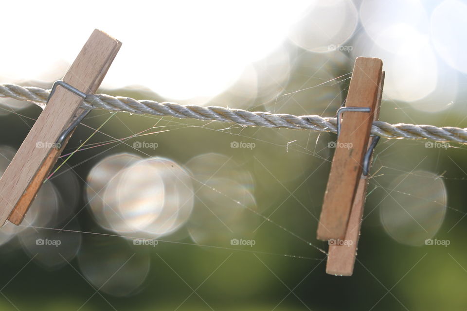 Bokeh closeup: two wood clothespins clothespegs on outdoor clothesline