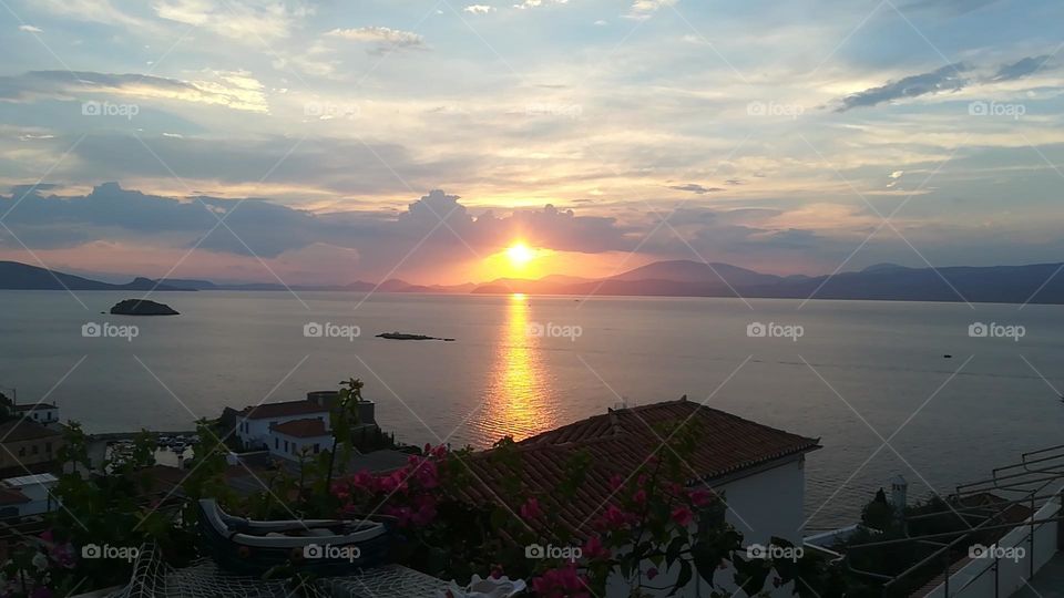 Admiring the horizon in a small greek island, Hydra. The calm sea and the colorful sky bring peace of mind.