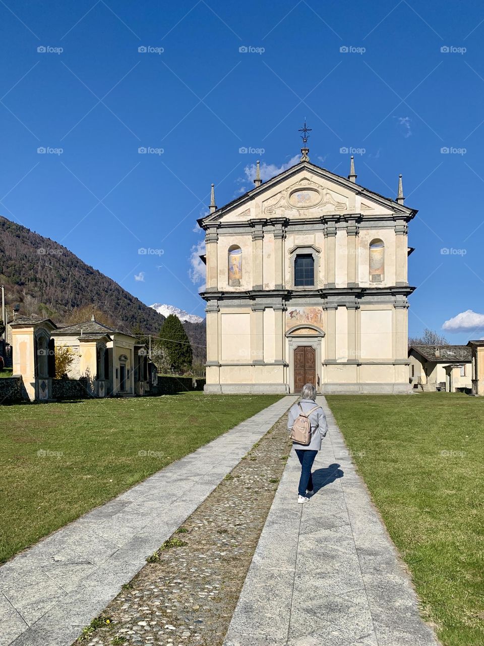 church in the Rhaetian Alps with a large lawn overlooking the churchyard with visitor