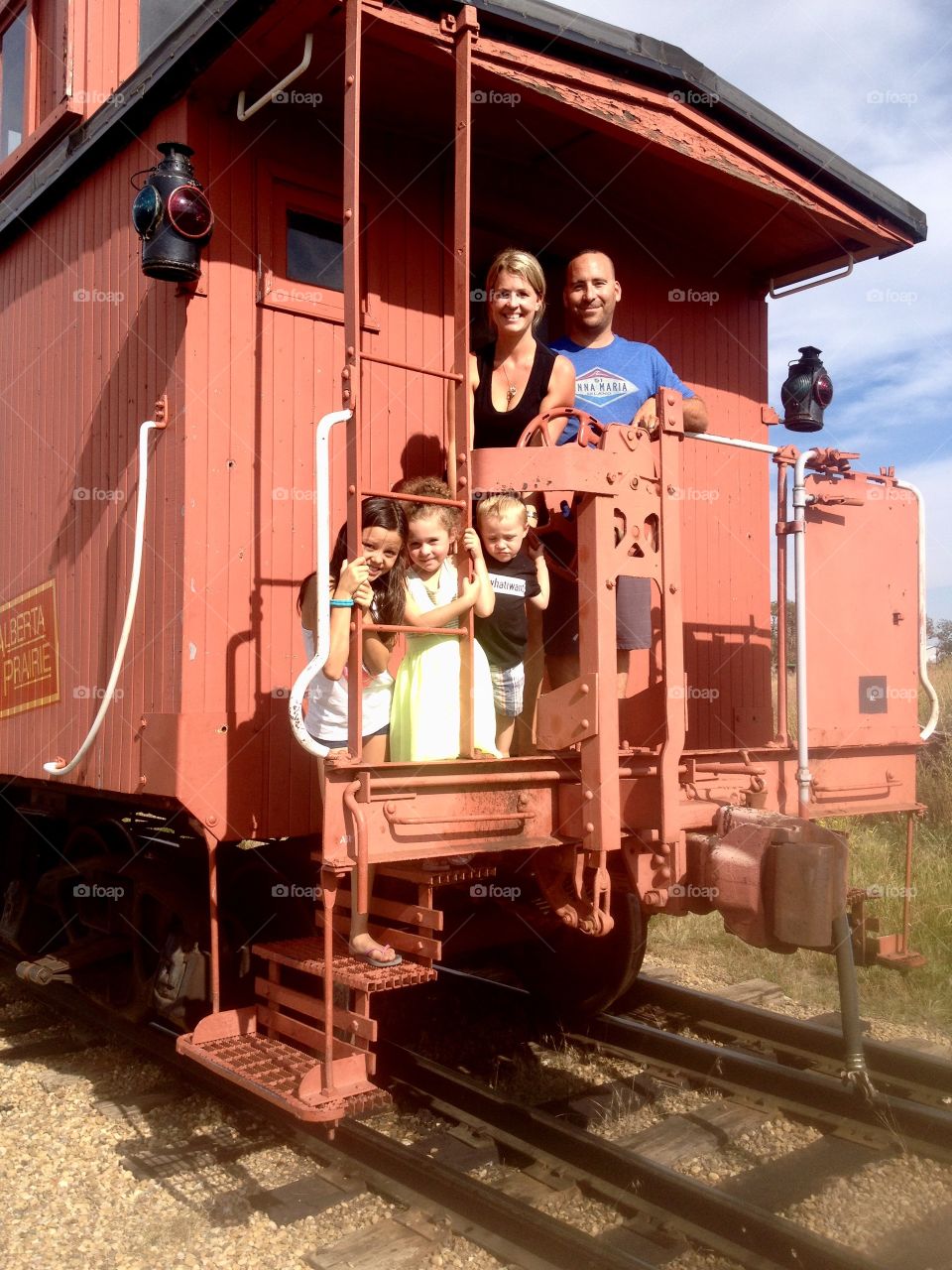 Happy family standing in train engine