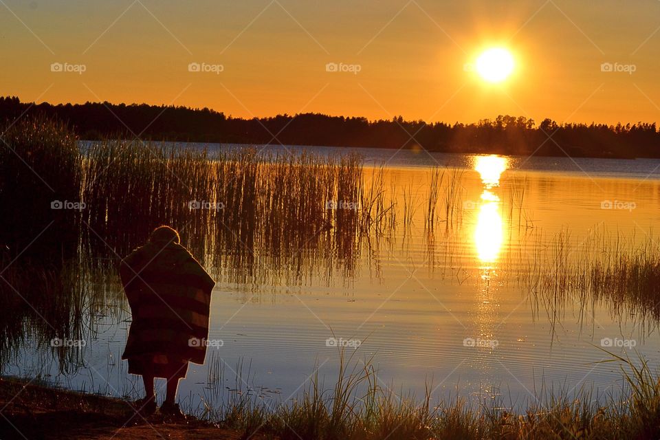 Playing. Boy playing beside the water during golden hour