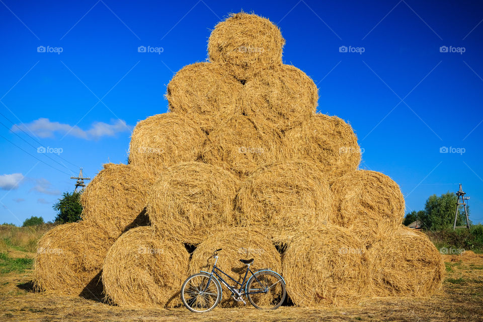 Round wheat bales of straw with bycicle