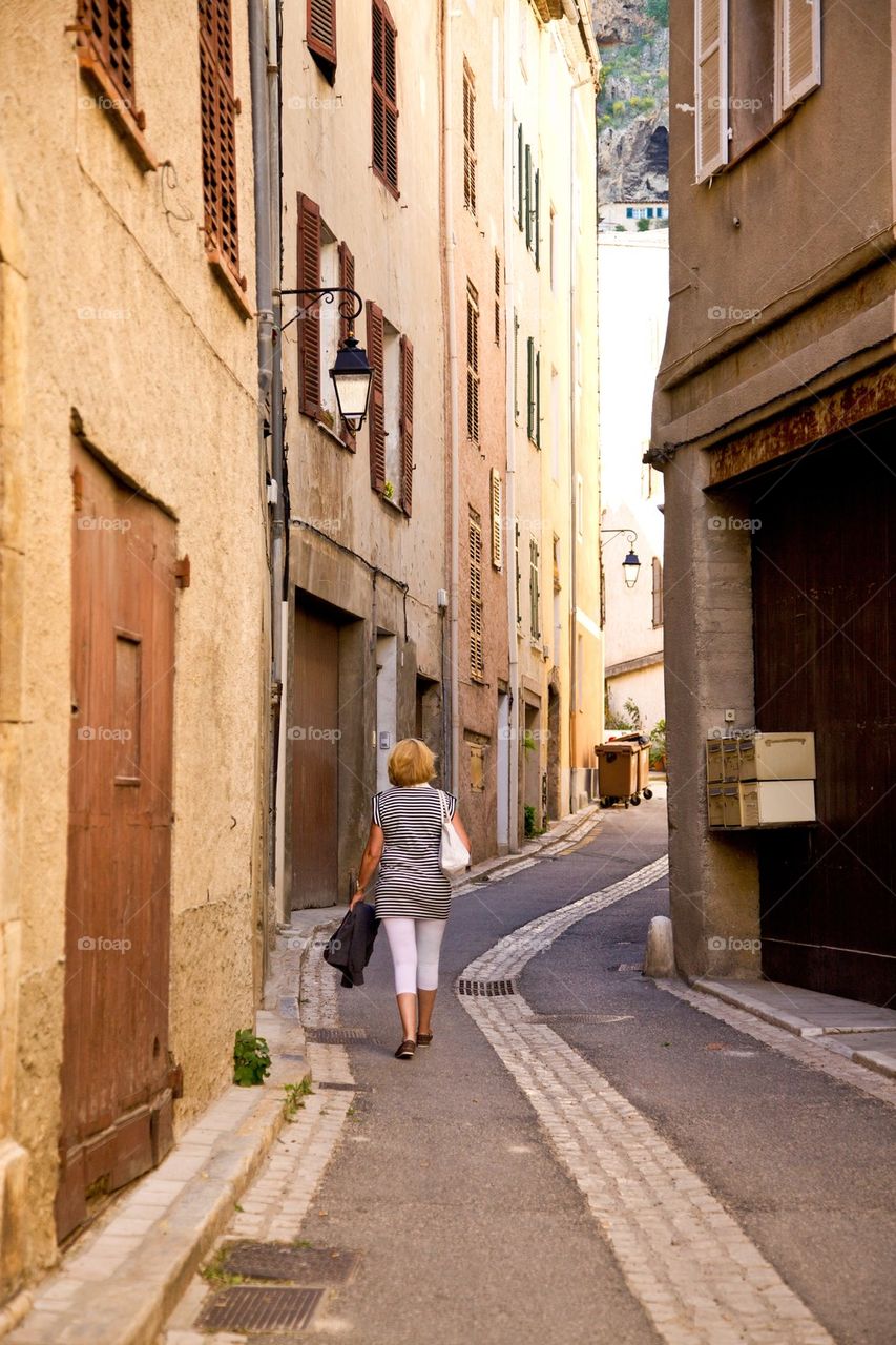 Woman walking in a village in Provence.