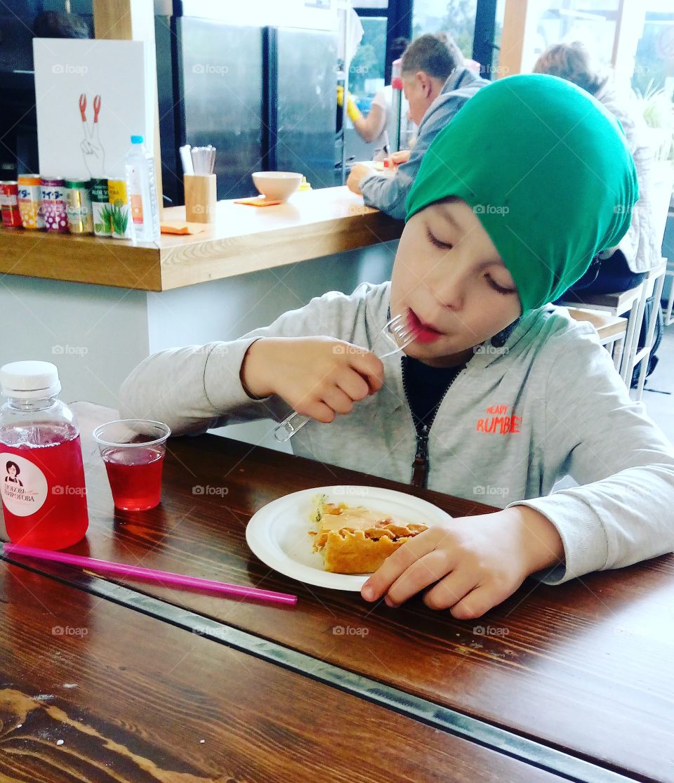 the boy is eating a food court