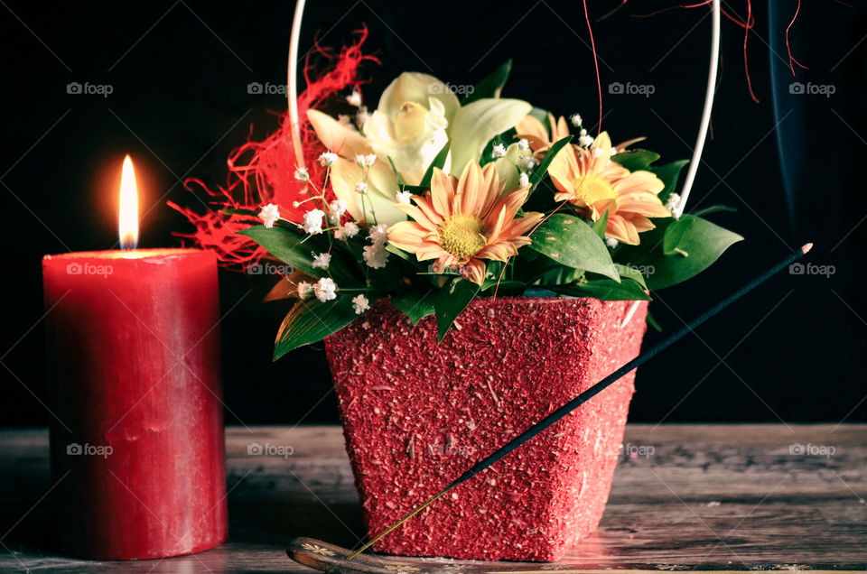 Red candle, flowers and scented stick