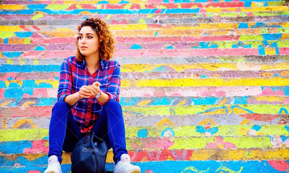 Young woman sitting on colorful steps