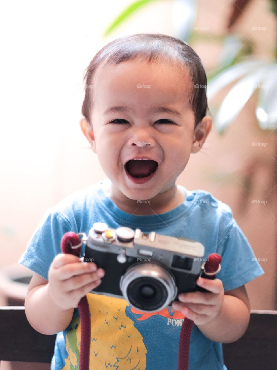 A happy Adam holding his grandfather’s camera