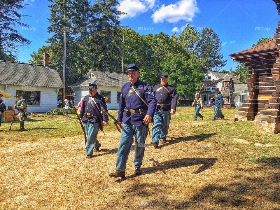 Military soldiers walking on field with weapon