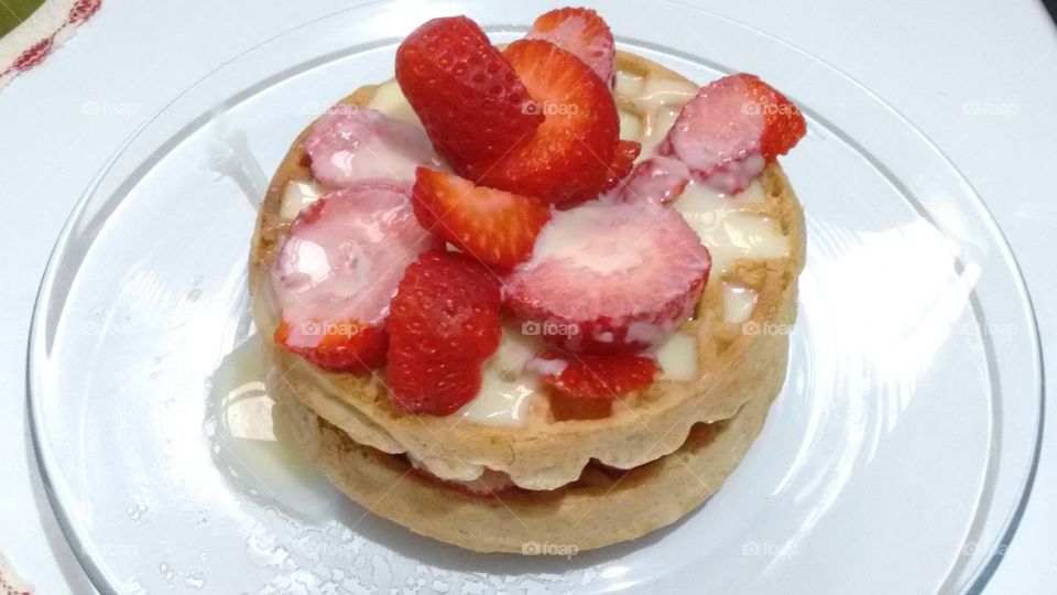 waffles with strawberries and Sweet condensed milk on a plate