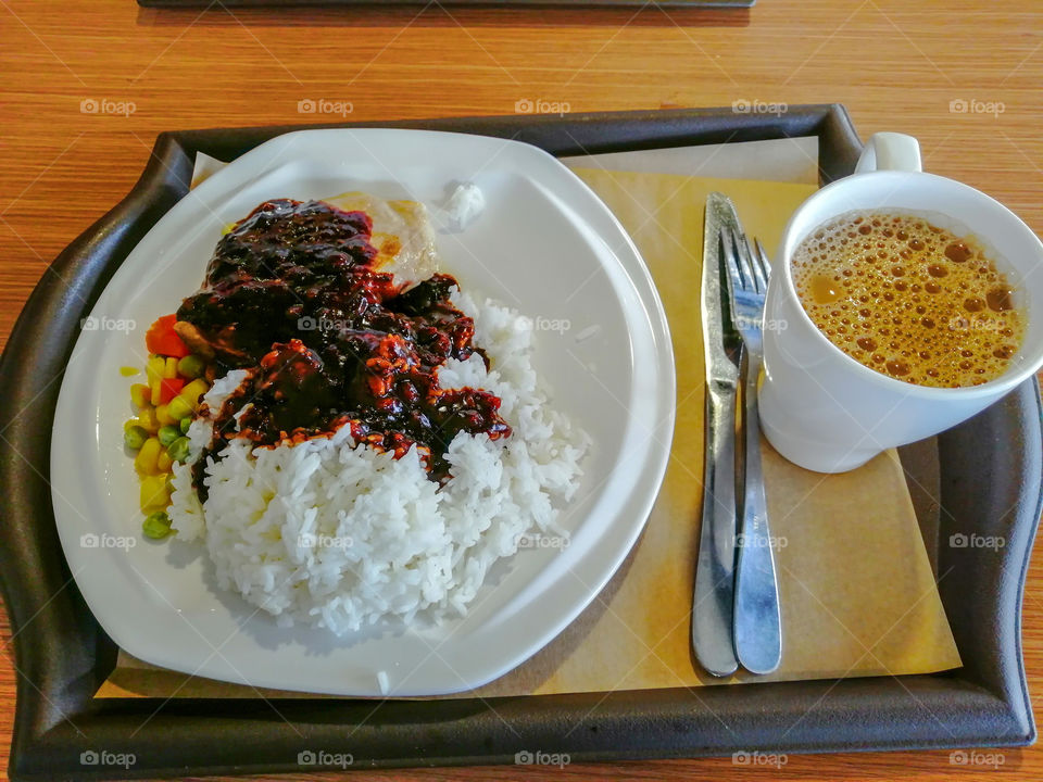 Pork chop in black pepper sauce and a cup of coffee