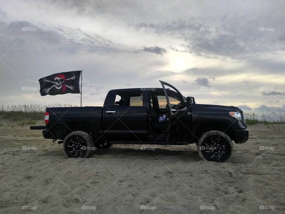 Black truck on the beach