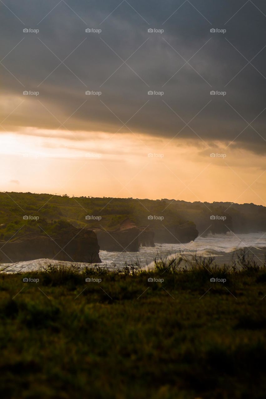 sunrise on the edge of a rocky beach