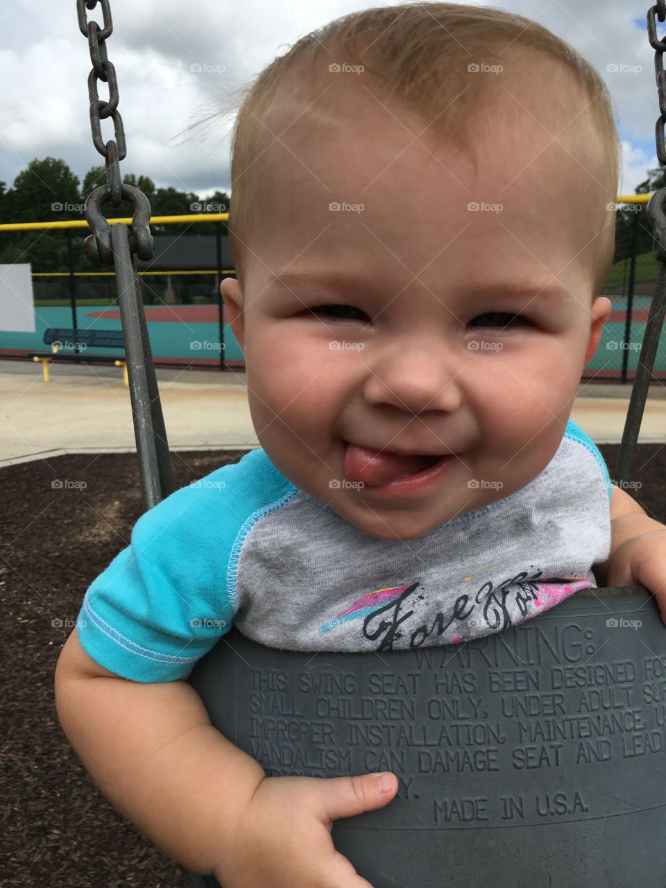 Little boy enjoying on swing in park