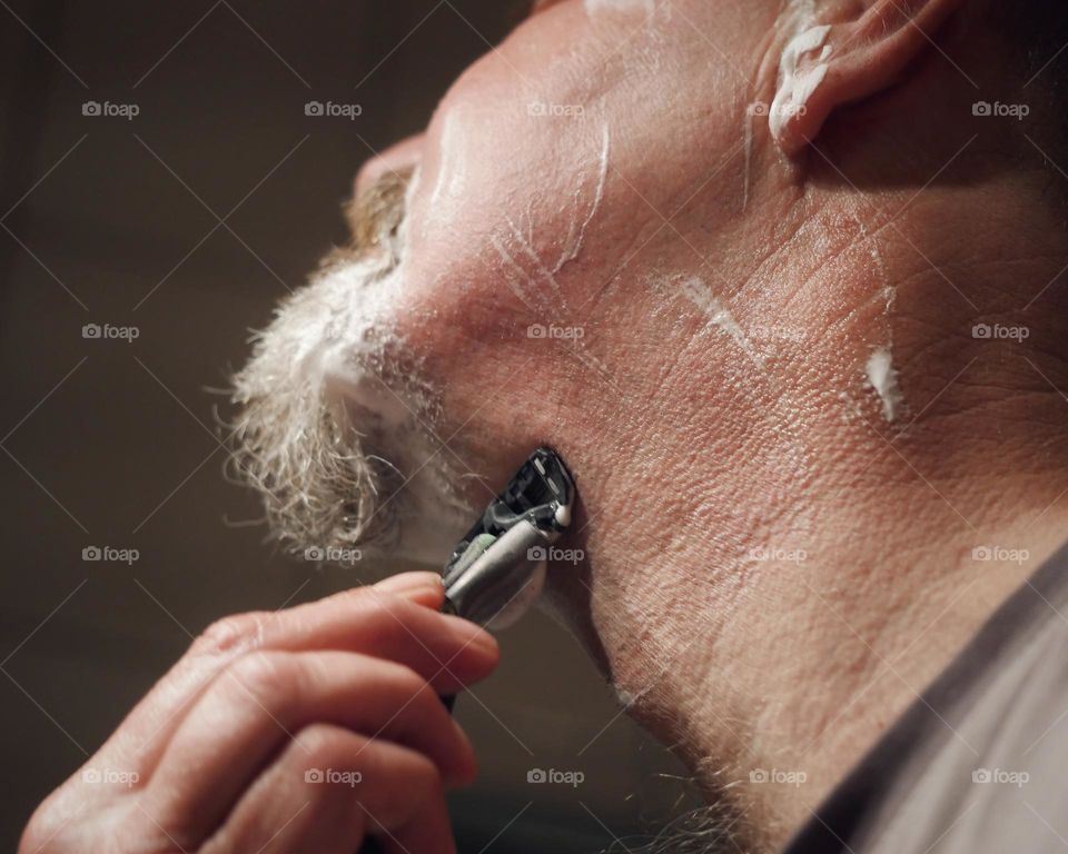 Close-up of man shaving