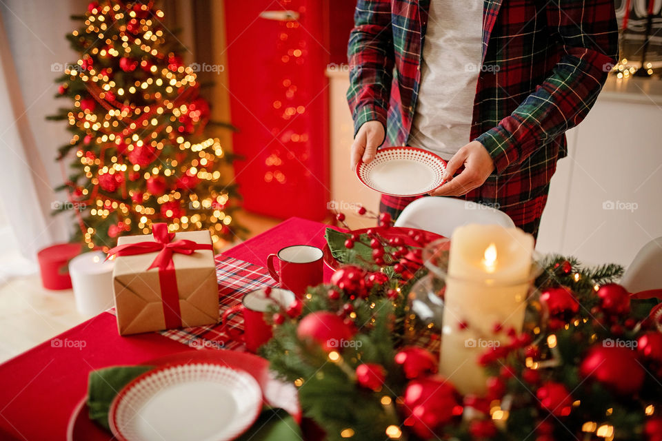 man sets a beautiful decorated winter table for a festive dinner.  Merry Christmas and Happy New Year.