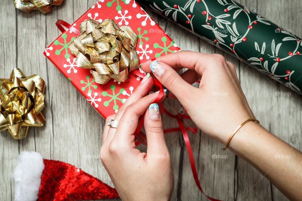 Woman's hands with beautiful manicure are wrapping a present