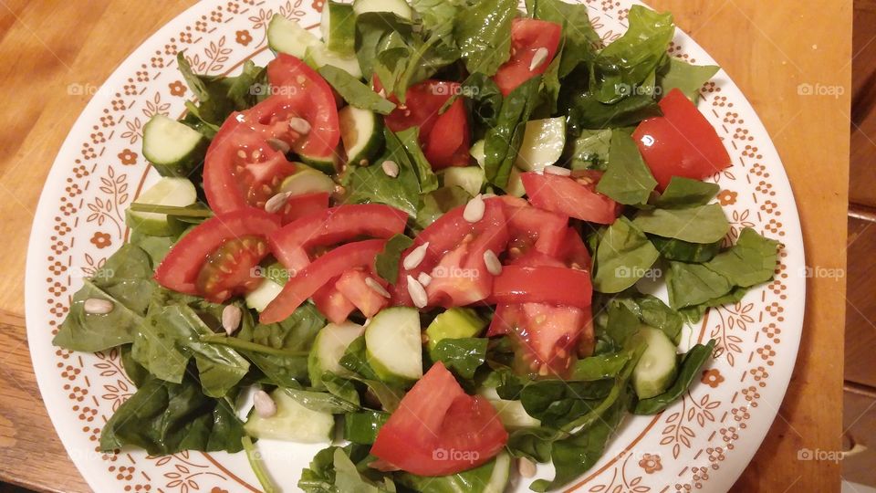 Salad Supper. Fresh spinach, cucmber, and tomato salad topped with raw sunflower seeds, extra virgin olive oil and fresh lemon juice.