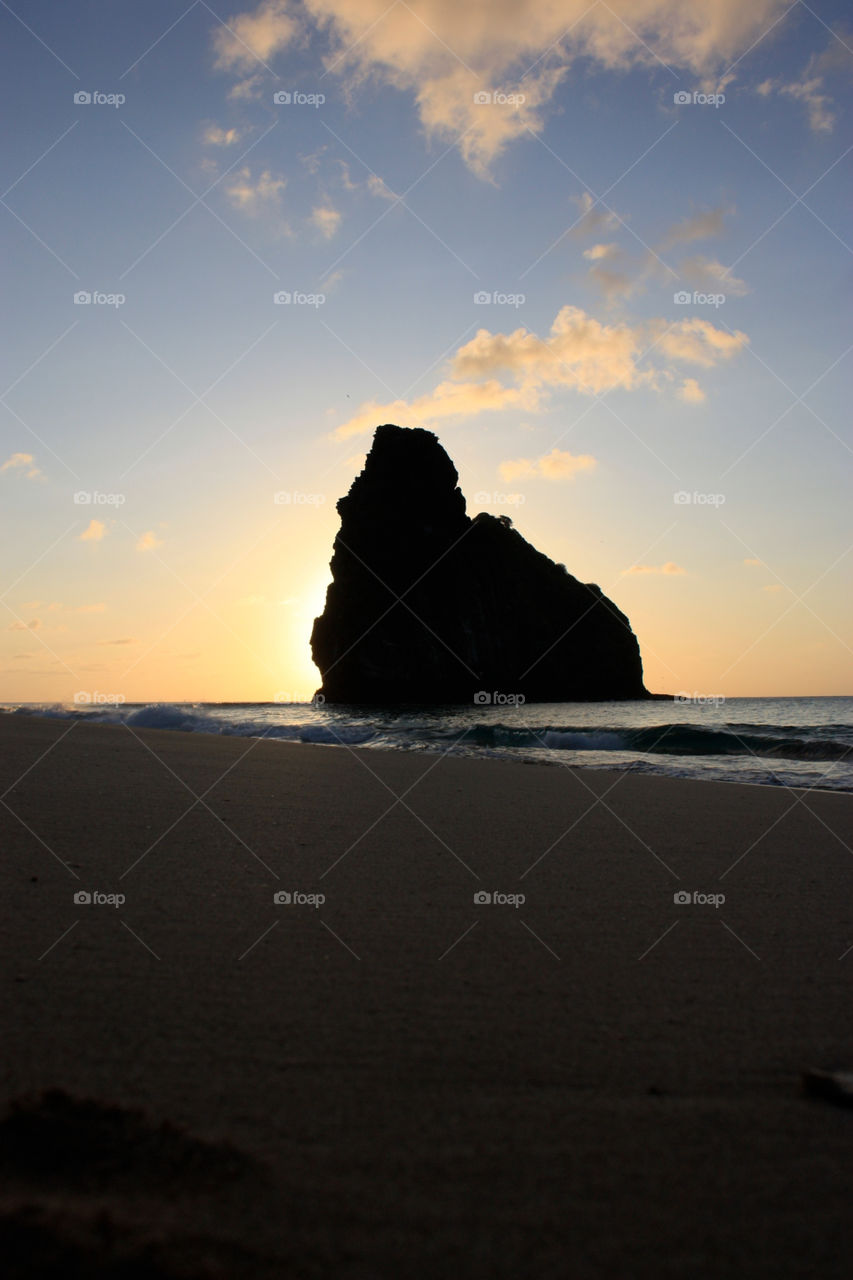 Silhouette of rock formation on beach